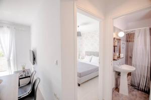 a bedroom with a bed and a sink and a mirror at Ten Suns 9 in Lixouri
