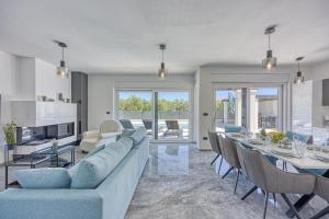 sala de estar con sofá y mesa con sillas en Villa-Osmium Galizana, en Galižana