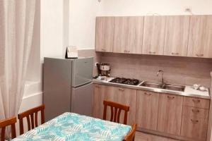 uma cozinha com um frigorífico e uma mesa com cadeiras em Casa Vacanze Aversa centro em Aversa
