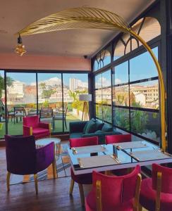 a restaurant with tables and chairs and a large window at Central Hotel Tana in Antananarivo