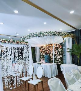 een huwelijksreceptie met witte stoelen en een bloemaltaar bij Central Hotel Tana in Antananarivo