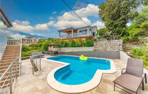 a swimming pool with two chairs and a house at Stunning Home In Drvenik Veliki With 4 Bedrooms, Wifi And Outdoor Swimming Pool in Drvenik Veli