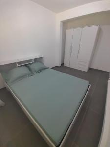 een witte kamer met een bed en een kast bij Maison ika in Le François