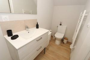a bathroom with a white sink and a toilet at Maison Charme & Mer à Dunkerque in Dunkerque