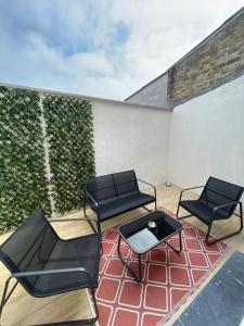 three chairs and a table on a patio at Maison Charme & Mer à Dunkerque in Dunkerque