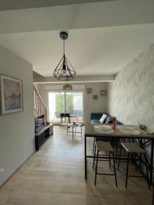 a dining room and living room with a table and chairs at Maison Charme & Mer à Dunkerque in Dunkerque +8 photos