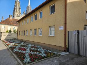 Ein Gebäude mit einem Haufen Blumen auf der Seite. in der Unterkunft Gerardus Apartmani 2 in Vršac