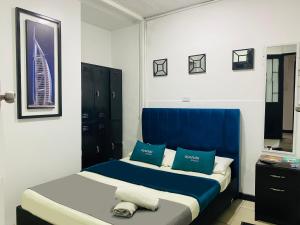a bedroom with two beds with blue and white pillows at Hotel Bogota Home in Bogotá
