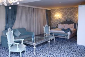 een hotelkamer met een bed, een bank en een tafel bij Deluxe Hotel Ganja in Ganja