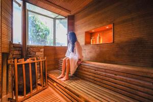 a woman is sitting in a sauna at Spa Posse do Corpo in Petrópolis