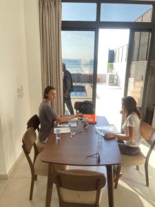 a group of people sitting around a table with a view at Follow Sea Villa in Sowayma