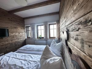 a bedroom with two beds and a wooden wall at Gmundnerberghaus in Altmünster