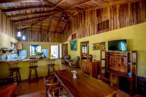 una sala de estar con una mesa de madera y un bar en Casa de la Naturaleza, en Cóbano