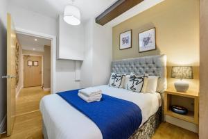 a bedroom with a large bed with a blue blanket at Host & Stay - Queen Square Apartment in Liverpool