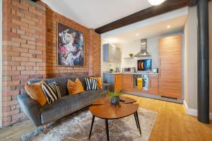 un soggiorno con divano e muro di mattoni di Host & Stay - Queen Square Apartment a Liverpool