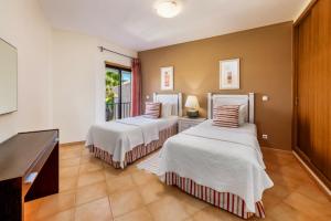 a bedroom with two beds and a table at Estrela da Luz Resort in Luz