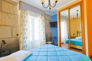 a bedroom with a blue bed and a mirror at Residencial Bem Estar in Chaves