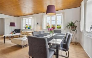 a dining room and living room with a table and chairs at 2 Bedroom Awesome Apartment In Hejls in Hejls