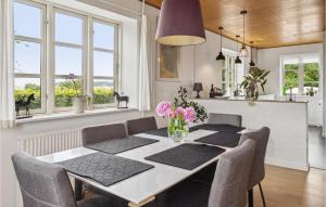 a dining room with a table and chairs and windows at 2 Bedroom Awesome Apartment In Hejls in Hejls