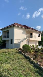 ein weißes Haus mit einem Balkon und einem Hof in der Unterkunft Coral House near Villa Bluu in Jambiani