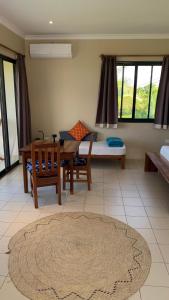 - un salon avec une table et un lit dans l'établissement Coral House near Villa Bluu, à Jambiani