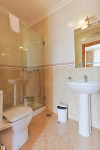 a bathroom with a toilet and a sink and a shower at Residencial Bem Estar in Chaves