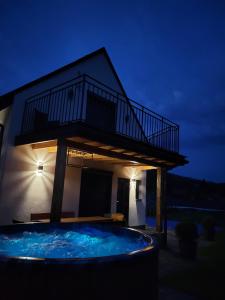 eine Villa mit einem Pool in der Nacht in der Unterkunft Domki u Duszy in Brenna
