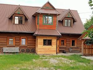 a wooden house with a bench in front of it at Pan Tadeusz in Nowy Targ