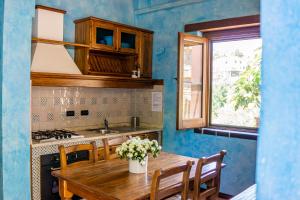 cocina con mesa de madera y fregadero en Locanda Le Tre Sorelle, en Casal Velino