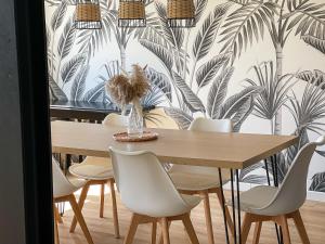 mesa de comedor y sillas con papel pintado tropical en Maison Privilège Nature à La Petite Pierre en La Petite-Pierre