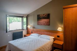 1 dormitorio con cama y ventana en Hotel La Scottiglia e Ristorante, en Seggiano