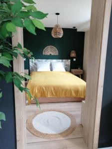 1 dormitorio con cama amarilla y pared verde en Maison Privilège Nature à La Petite Pierre en La Petite-Pierre