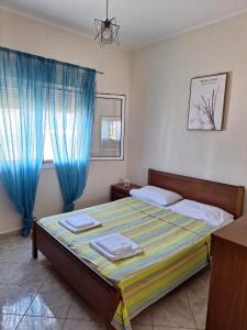 a bedroom with a bed with blue curtains at Xristos Villa in Vrasná