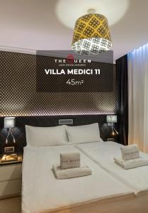 1 dormitorio con 1 cama con un cartel en la pared en The Queen Luxury Apartments - Villa Medici en Luxemburgo