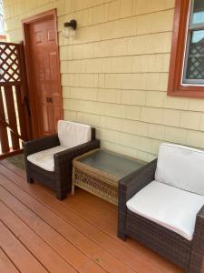 two wicker chairs and a table on a porch at Angie's Guest Cottage in Virginia Beach