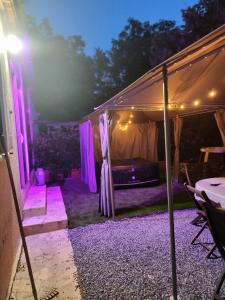 a tent with purple lights and a bed in it at Chez Cathy et Philippe in Vérargues