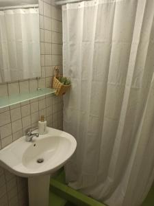a bathroom with a sink and a shower curtain at Letos Apartment Sky in Kavála +11 photos