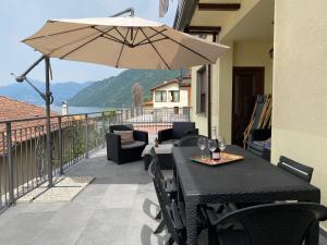 a black table and chairs with an umbrella on a balcony at Gere house in Lezzeno