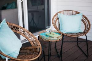 two wicker chairs with blue pillows on a porch at Beach 106 Direct Access Near Downtown Tart Trail in Traverse City