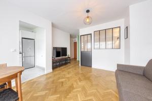 a living room with a couch and a wooden floor at L'Appartement d'Art et de Lumière in Clichy