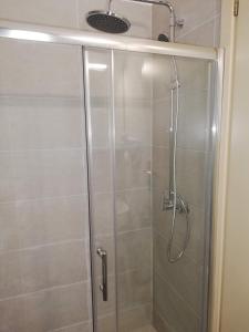 W łazience znajduje się prysznic ze szklanymi drzwiami. w obiekcie Hotel Erato w mieście Chorefto