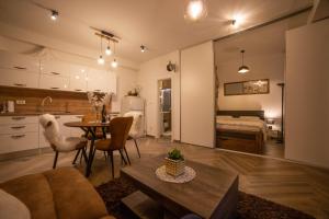 1 dormitorio y sala de estar con mesa y cocina. en Madona di Sinj en Sinj