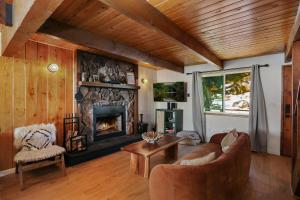 a living room with a fireplace and a couch at Le Chalet of Arrowbear Lake in Running Springs