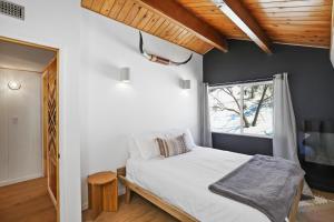 Schlafzimmer mit einem Bett und einem Fenster in der Unterkunft Le Chalet of Arrowbear Lake in Running Springs