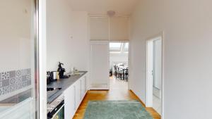 a kitchen with white cabinets and a green rug at Helle Ferienwohnung in 1a Lage in Leipzig