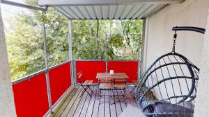 - une terrasse couverte avec une balançoire, une table et des chaises dans l'établissement Helle Ferienwohnung in 1a Lage, à Leipzig