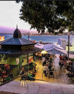 アルマダにあるTEJO HOUSE RIVER Lisbon (Cacilhas)の水の見えるレストランに座る人々