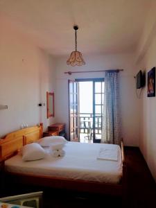 sypialnia z łóżkiem i oknem z widokiem w obiekcie Hotel Erato w mieście Chorefto