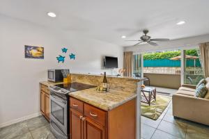 a kitchen with a counter top and a living room at 2Br Kauai Kailani Condo, Pool, walk to Ocean & Shops, AC KK117 in Kapaa