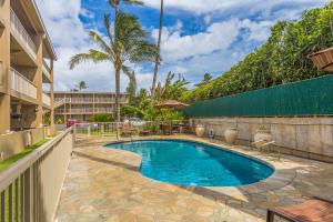 a swimming pool in a yard next to a building at 2Br Kauai Kailani Condo, Pool, walk to Ocean & Shops, AC KK117 in Kapaa